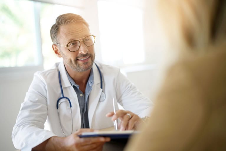 Médico conversando com paciente durante consulta de segunda opinião